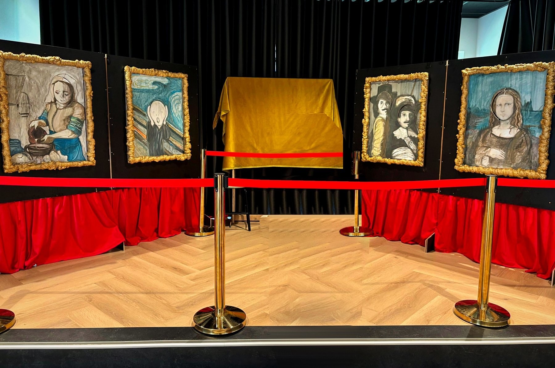 Het complete decor op het podium: Het melkmeisje, De Schreeuw, De Nachtwacht en de Mona Lisa in gouden lijsten achter rode afzetkoorden
